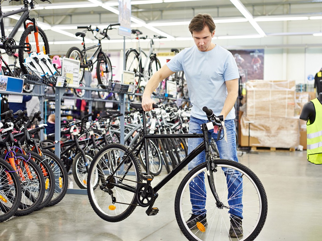Man checks bicycle before buying in sports shop