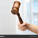 someones hand holding Wooden Law Gavel